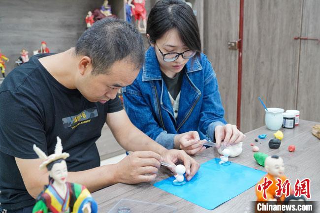 <a target='_blank'  data-cke-saved- >中新社</a>記者(右)現(xiàn)場(chǎng)體驗(yàn)面塑制作過(guò)程。　陳爭(zhēng)強(qiáng) 攝