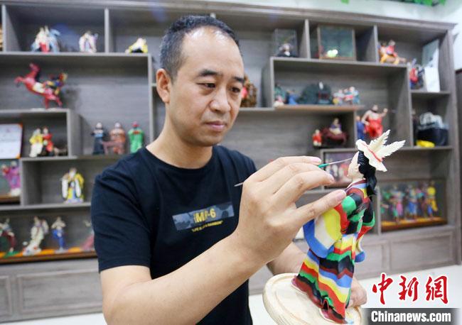 圖為安秋平正在創(chuàng)作代表隴南文縣民俗的《白馬人》作品?！「哒?攝