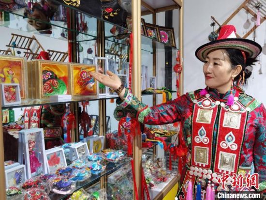 圖為身著民族服飾的隴原巧手展示手工藝品。(資料圖) 徐雪 攝