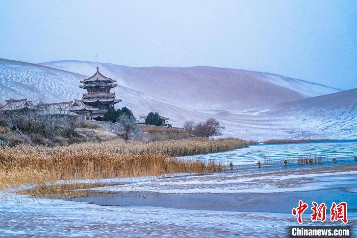 2021年11月28日，雪落鳴沙山月牙泉景區(qū)?！⊥醣筱y 攝