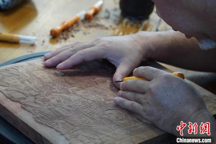 圖為徐晉林湊近木板，近距離制作雕版畫?！【琶赖┰?　攝