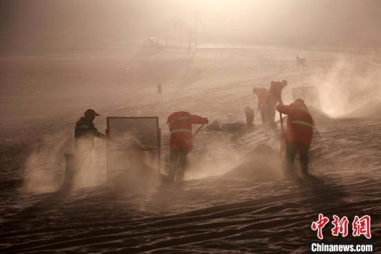 圖為敦煌市鳴沙山月牙泉景區(qū)“駱駝保姆”清理駱駝糞便?！垥粤?攝
