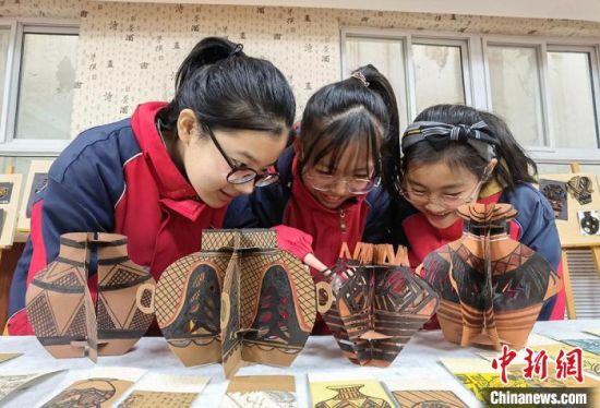 圖為學(xué)生用紙創(chuàng)作的立體彩陶?！⒂裉?攝