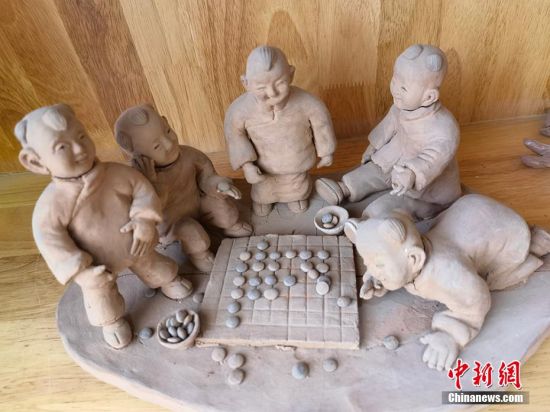 圖為泥塑作品展現(xiàn)下棋場景。 劉玉桃 攝