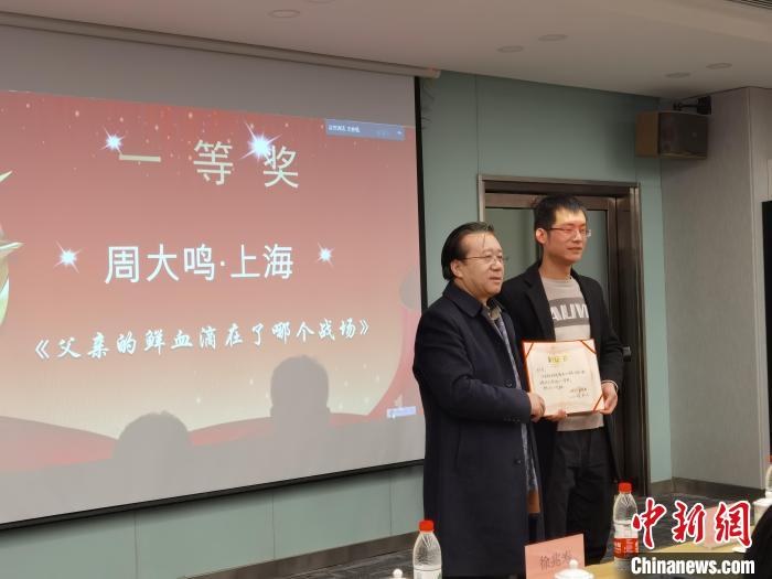 圖為作家、西北師范大學(xué)新聞與傳媒學(xué)院院長徐兆壽頒發(fā)一等獎(jiǎng)證書，代領(lǐng)獎(jiǎng)?wù)呱吓_領(lǐng)獎(jiǎng)?！钅?攝