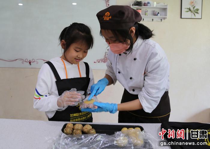 圖為在甘臺胞小朋友在工作人員指導(dǎo)下制作月餅。九美旦增 攝