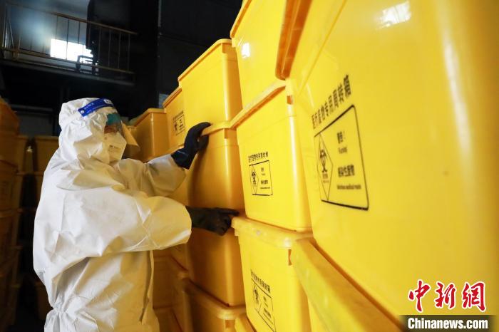 圖為工作人員搬運(yùn)醫(yī)療廢物專用周轉(zhuǎn)箱?！∥航ㄜ?攝