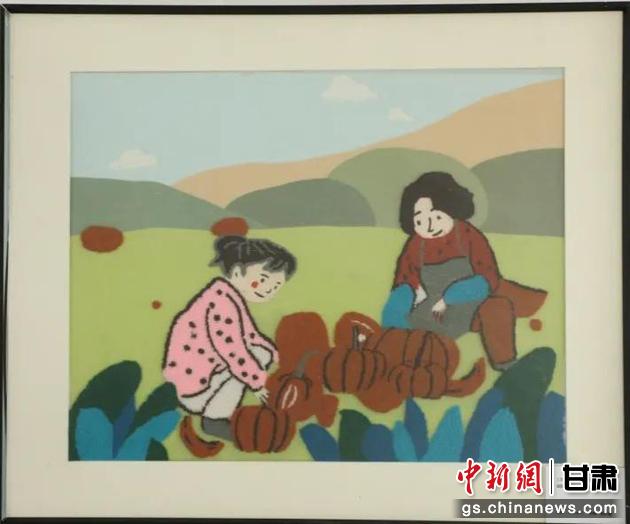 嘉峪關(guān)市新城鎮(zhèn)新城村農(nóng)業(yè)產(chǎn)業(yè)園區(qū)內(nèi)，母女兩人在摘南瓜。刺繡 馬艾米乃 繡稿 敬紅霞