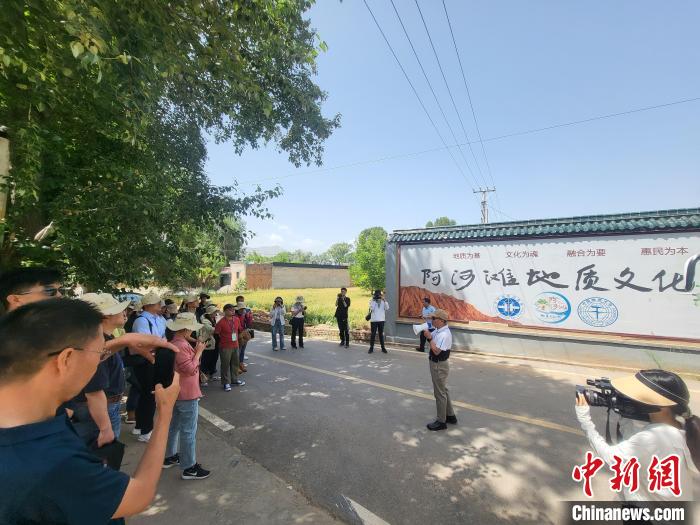 圖為中國地質(zhì)大學(北京)教授張緒教介紹村落情況?！『衍?攝