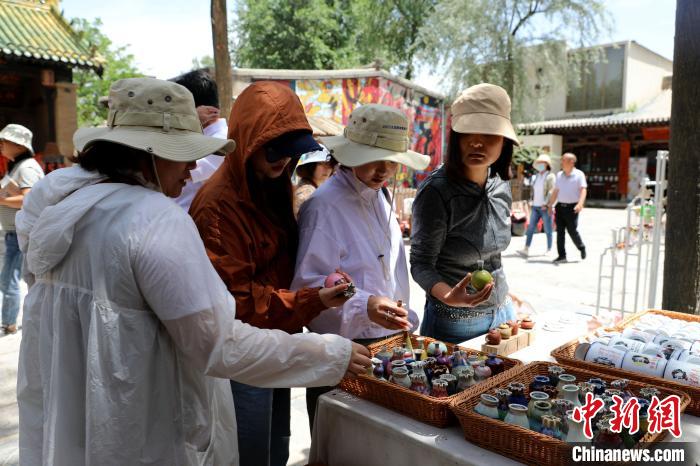 圖為民眾挑選手工藝產(chǎn)品?！⊙Φ?攝