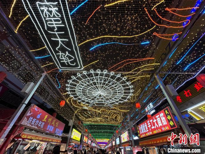 圖為明清街夜市燈光點(diǎn)亮具有武威文化元素的“摩天輪”彩燈?！〈魑牟?攝</p><p>