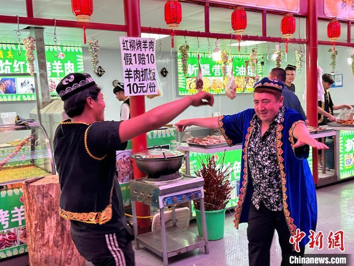 圖為餐飲經(jīng)營(yíng)者在“西涼不夜城”跳起舞蹈引客?！〈魑牟?攝</p><p>