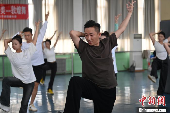 6月6日，在甘肅敦煌青年夜校課程中，青年學(xué)員學(xué)習(xí)敦煌舞課程。李亞龍 攝　　