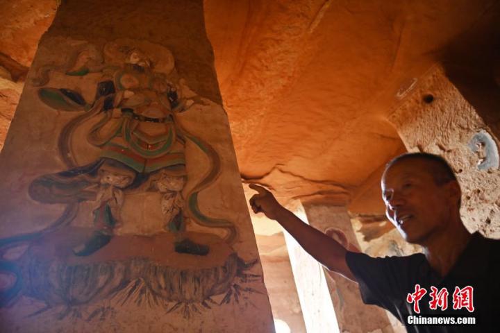 7月15日，甘肅省平?jīng)鍪袥艽h百里石窟長(zhǎng)廊羅漢洞石窟內(nèi)，該窟文保員郭建平介紹窟內(nèi)石刻彩繪壁畫(huà)。郭建平家中三代人曾自發(fā)保護(hù)羅漢洞石窟。羅漢洞石窟遺存40余個(gè)窟龕，以北魏至清代風(fēng)格為主。中新社記者 李亞龍 攝</p>
<p>