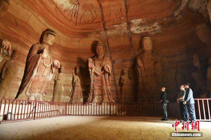 7月15日，游人參觀甘肅省平?jīng)鍪袥艽h百里石窟長(zhǎng)廊中的南石窟寺1號(hào)窟。百里石窟長(zhǎng)廊位于涇川縣境內(nèi)，由512個(gè)石窟、5眼窟中石井組成，現(xiàn)存王母宮石窟、鳳凰山石窟、南石窟寺、丈八寺石窟、羅漢洞石窟、太山寺石窟等規(guī)模較大的石窟群，還有數(shù)量眾多的小石窟群。南石窟寺開(kāi)鑿于北魏永平三年，其中1號(hào)窟屬于大型七佛窟，七佛高達(dá)6米。中新社記者 李亞龍 攝