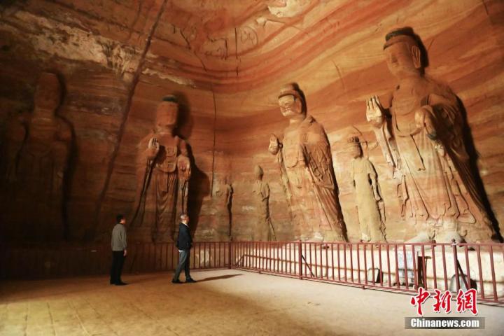 7月15日，游人參觀甘肅省平?jīng)鍪袥艽h百里石窟長(zhǎng)廊中的南石窟寺1號(hào)窟。百里石窟長(zhǎng)廊位于涇川縣境內(nèi)，由512個(gè)石窟、5眼窟中石井組成，現(xiàn)存王母宮石窟、鳳凰山石窟、南石窟寺、丈八寺石窟、羅漢洞石窟、太山寺石窟等規(guī)模較大的石窟群，還有數(shù)量眾多的小石窟群。南石窟寺開(kāi)鑿于北魏永平三年，其中1號(hào)窟屬于大型七佛窟，七佛高達(dá)6米。中新社記者 李亞龍 攝