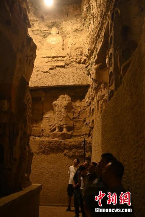 7月15日，游人參觀甘肅省平?jīng)鍪袥艽h百里石窟長(zhǎng)廊中的王母宮石窟。百里石窟長(zhǎng)廊位于涇川縣境內(nèi)，由512個(gè)石窟、5眼窟中石井組成，現(xiàn)存王母宮石窟、鳳凰山石窟、南石窟寺、丈八寺石窟、羅漢洞石窟、太山寺石窟等規(guī)模較大的石窟群，還有數(shù)量眾多的小石窟群。王母宮石窟又名千佛洞，該窟設(shè)計(jì)宏大，造像生動(dòng)，窟內(nèi)擁有造像數(shù)百尊，是較為珍貴的佛教文化遺存。中新社記者 李亞龍 攝</p>
<p>