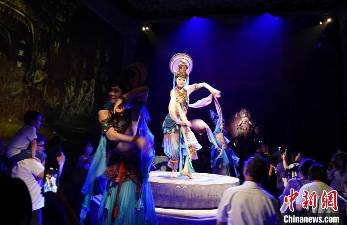 《樂動敦煌》是全球首部洞窟式沉浸體驗劇，利用真人與數(shù)字影像虛實交換實現(xiàn)沉浸式體驗。圖為2023年8月28日晚，《樂動敦煌》演出。(資料圖)中新社記者 毛建軍 攝