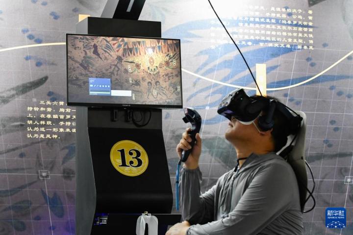 7月22日，游客借助VR設(shè)備沉浸式游覽莫高窟第285窟虛擬場景。新華社記者 郎兵兵 攝